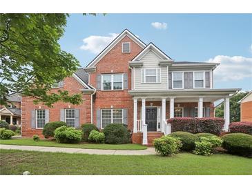 Charming two-story brick home with a welcoming front porch and manicured lawn at 112 Tara Blvd, Loganville, GA 30052