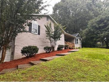 Charming home with landscaped yard and stone steps leading to the entrance at 80 Brooks Ln, Dallas, GA 30157