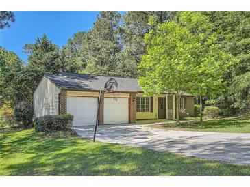 Charming brick and siding home with attached two-car garage and a basketball hoop in the driveway at 2948 Sagewood Dr, Snellville, GA 30039