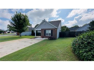 Charming single-story home featuring manicured lawn, gray siding and a brick accent wall at 1972 Brittania Cir, Woodstock, GA 30188