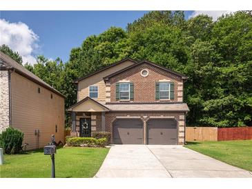 Charming two-story home featuring a brick facade, two-car garage, and a well-maintained front yard at 2521 Livingston Ct, Loganville, GA 30052