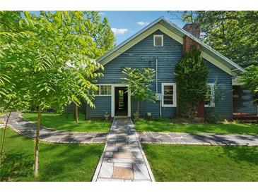 Charming blue house with a stone pathway leading to the front door and lush green lawn at 13795 Arnold Mill Rd, Roswell, GA 30075