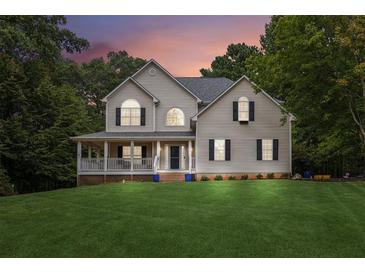 Charming two-story home with a spacious front yard and inviting covered porch at 25 Grange Ct, Sharpsburg, GA 30277