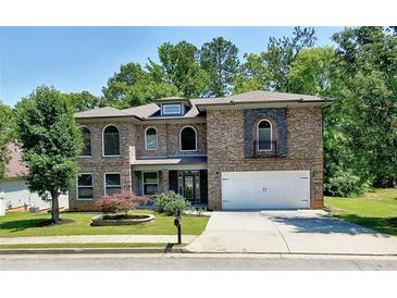 Charming two-story brick home with a manicured front yard and attached two-car garage at 4590 River Stone Trl, Douglasville, GA 30135