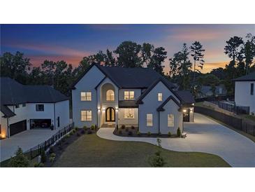 Stunning two-story home with landscaped front yard and well-lit driveway at dusk at 2631 Sardis Way, Buford, GA 30519