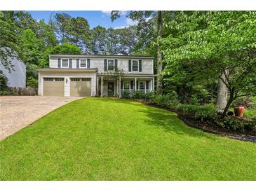 Charming two-story home with a well-manicured lawn, inviting front porch, and an attached two-car garage at 119 Laurel Mill Ct, Roswell, GA 30076