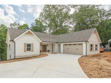 Charming single-Gathering home with white siding, stone accents, attached garage and concrete driveway at 912 Oak Dr, Woodstock, GA 30189