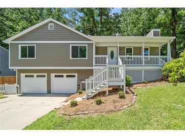 Charming home featuring a welcoming front porch, two-car garage and mature trees at 1080 Rackley Nw Way, Kennesaw, GA 30144