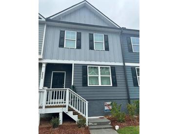 Charming two-story townhome featuring neutral siding, black shutters, and a welcoming front porch at 2832 Saratoga Lake Vw, Decatur, GA 30034