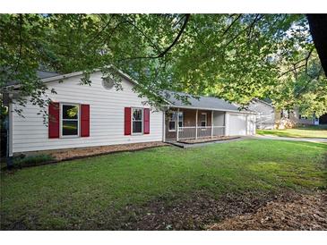 Cozy single-story home featuring red shutters and a charming front porch, nestled in a wooded lot at 11006 Clearwater Dr, Hampton, GA 30228