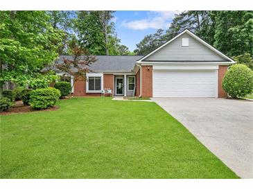 Beautifully landscaped front yard with a charming brick home and a two-car garage at 1208 Brandl Sw Dr, Marietta, GA 30008