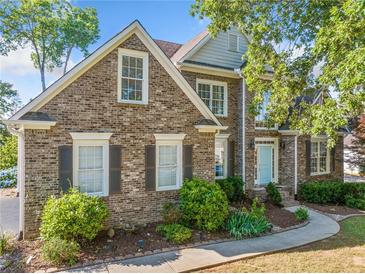 Charming brick two-story home with a light blue door and well-maintained landscaping at 4295 Cami Way, Buford, GA 30519