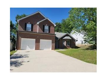 Two-story brick home with a two-car garage and a well-maintained front lawn at 1752 Spring Hill Cv, Lithonia, GA 30058