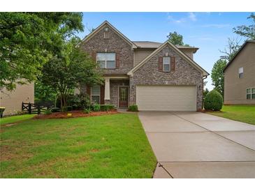 Charming two-story brick home featuring a well-manicured lawn and a two-car garage at 4650 Pleasant Woods Dr, Cumming, GA 30028