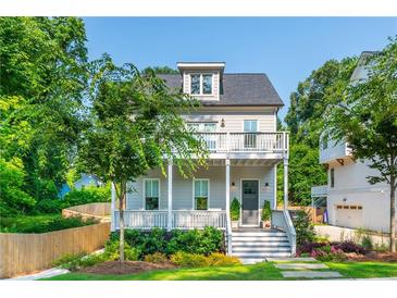 Charming two-story home with a gray exterior, inviting front porch, and beautifully landscaped front yard at 940 Longley Nw Ave, Atlanta, GA 30318