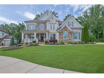 Charming two-story home featuring a beautifully landscaped yard and inviting front porch at 3330 Riverwalk Way, Cumming, GA 30040