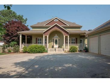 Charming home with a welcoming front porch, complemented by a spacious driveway and attached three-car garage at 105 Whippoorwill Way, Fayetteville, GA 30215