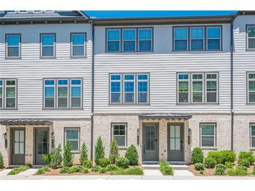 Charming townhome exterior with light brick, neutral siding, and professional landscaping at 3693 Allegretto Cir, Atlanta, GA 30339