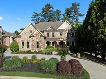 Beautiful two-story home featuring stone and brick with a manicured lawn and circular driveway at 8805 Marion Dr, Duluth, GA 30097