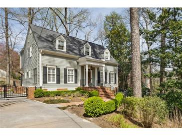 Charming home showcasing manicured landscaping, brick walkway, and gray siding beneath a shingled roof at 735 Longwood Nw Dr, Atlanta, GA 30305