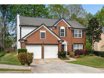 Charming brick two-story home featuring an attached two-car garage and manicured front lawn at 3925 Tugaloo River Dr, Duluth, GA 30097