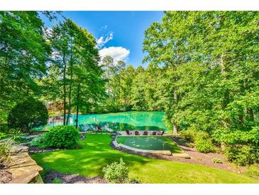 Beautiful backyard oasis with putting green, lake and wooded views, perfect for relaxation and outdoor enjoyment at 5675 Habersham Vly, Suwanee, GA 30024
