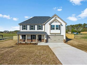 Two-story home with covered entry, gray roof, two-car garage, and neutral siding at 1707 Bouquet Way, Mcdonough, GA 30253