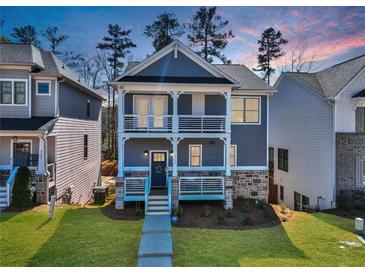 Charming two-story home featuring a double porch, stone accents, and well-manicured lawn at 5293 Hearthstone St, Stone Mountain, GA 30083