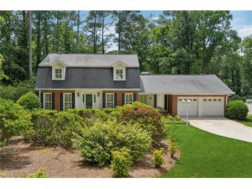 Charming two-story home with black shutters, a two-car garage, and beautifully landscaped front yard at 626 Cheatham Sw Dr, Marietta, GA 30064