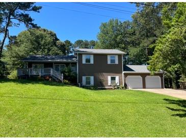 Charming two-story home featuring an attached two-car garage and a inviting front porch at 710 Wind Song Trce, Woodstock, GA 30189