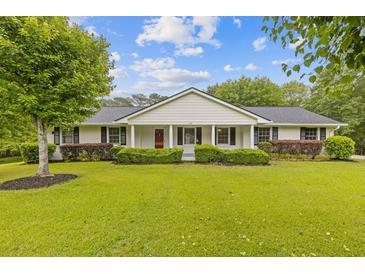 Charming home featuring a well-manicured lawn, attractive shrubbery and a welcoming front porch at 256 Teresa Ln, Loganville, GA 30052