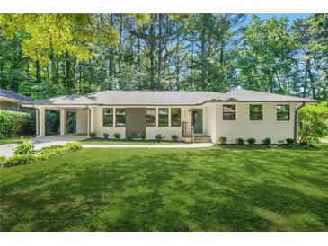 Charming brick home with manicured lawn, modern windows, and convenient carport at 3337 Toney Dr, Decatur, GA 30032