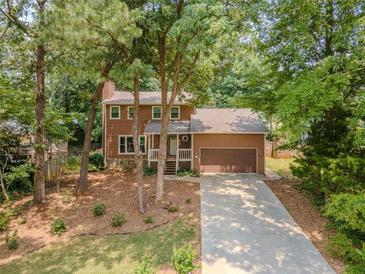 Charming two-story home with a well-manicured front yard, long driveway, and an attached two-car garage at 410 Hunters Cove Ct, Lawrenceville, GA 30044