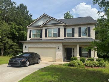 Charming two-story home with a well-manicured lawn and an attached two-car garage at 12351 Styron Dr, Hampton, GA 30228