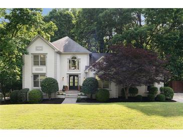 Charming two-story home features lush landscaping, a well-manicured lawn, and a stylish front entrance at 3390 River Ferry Dr, Alpharetta, GA 30022