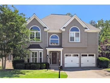 Charming two-story home featuring a well-manicured lawn, two-car garage, and stylish architectural details at 4527 Village Springs Run, Dunwoody, GA 30338