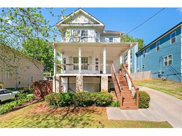 Charming two-story home with a covered front porch and well-maintained landscaping at 628 Warren Ave, Scottdale, GA 30079