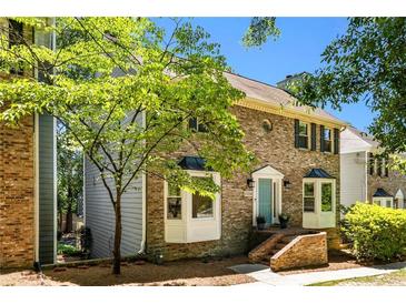 Charming brick home featuring a light blue front door, bay windows, and well-maintained landscaping at 2356 Defoors Ferry Nw Rd, Atlanta, GA 30318