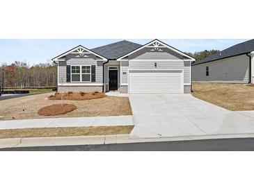 Charming single-story home featuring gray siding, a two-car garage, and a well-manicured front yard at 1624 Palladian Way, Lithonia, GA 30058
