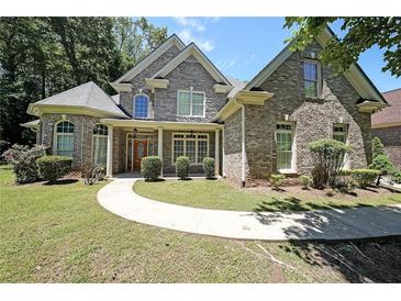 Charming two-story brick home with manicured lawn and inviting walkway, offers a warm and welcoming curb appeal at 375 Beracah Tr Southwest Sw Trl, Atlanta, GA 30331