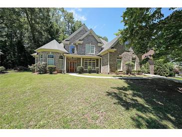 Charming two-story home with stone accents, lush lawn, and mature trees at 375 Beracah Tr Southwest Sw Trl, Atlanta, GA 30331