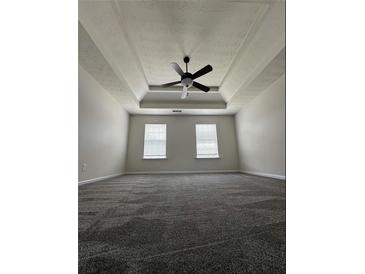 Spacious bedroom with neutral walls, tray ceiling with fan and wall to wall carpeting at 2837 Lakewater Way, Snellville, GA 30039