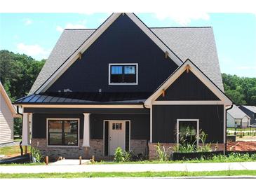 Beautiful two-story home featuring dark siding, white trim, and a covered front porch at 135 Old Alabama Rd, Emerson, GA 30137