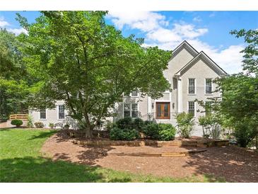 Stately home featuring lush landscaping, mulched beds and a symmetrical facade under a bright blue sky at 4223 N Mountain Ne Rd, Marietta, GA 30066