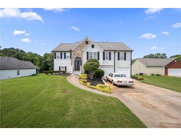Two-story home with a manicured lawn, stone accents, a driveway, and an attached two-car garage at 758 Beranda Cir, Douglasville, GA 30134