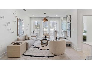Bright living room featuring a modern sofa, stylish decor, large windows, and a decorative rug on light wood floors at 775 Juniper St # 212, Atlanta, GA 30308