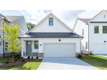 Charming craftsman-style home showcasing a clean white facade, a black metal roof, and an attached garage at 1818 Butterfly Way, Marietta, GA 30066