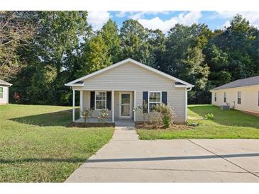 Charming single-story home with a well-manicured lawn, inviting entryway, and mature trees at 3645 Ten Oaks Cir, Powder Springs, GA 30127