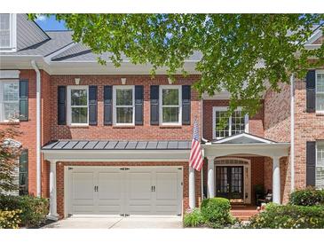 Charming brick home with a two-car garage, black shutters and an inviting front entrance at 4905 Village Green Dr, Roswell, GA 30075