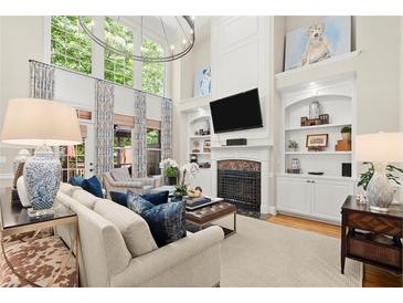 Bright living room featuring high ceilings, large windows, fireplace and stylish furniture at 4905 Village Green Dr, Roswell, GA 30075